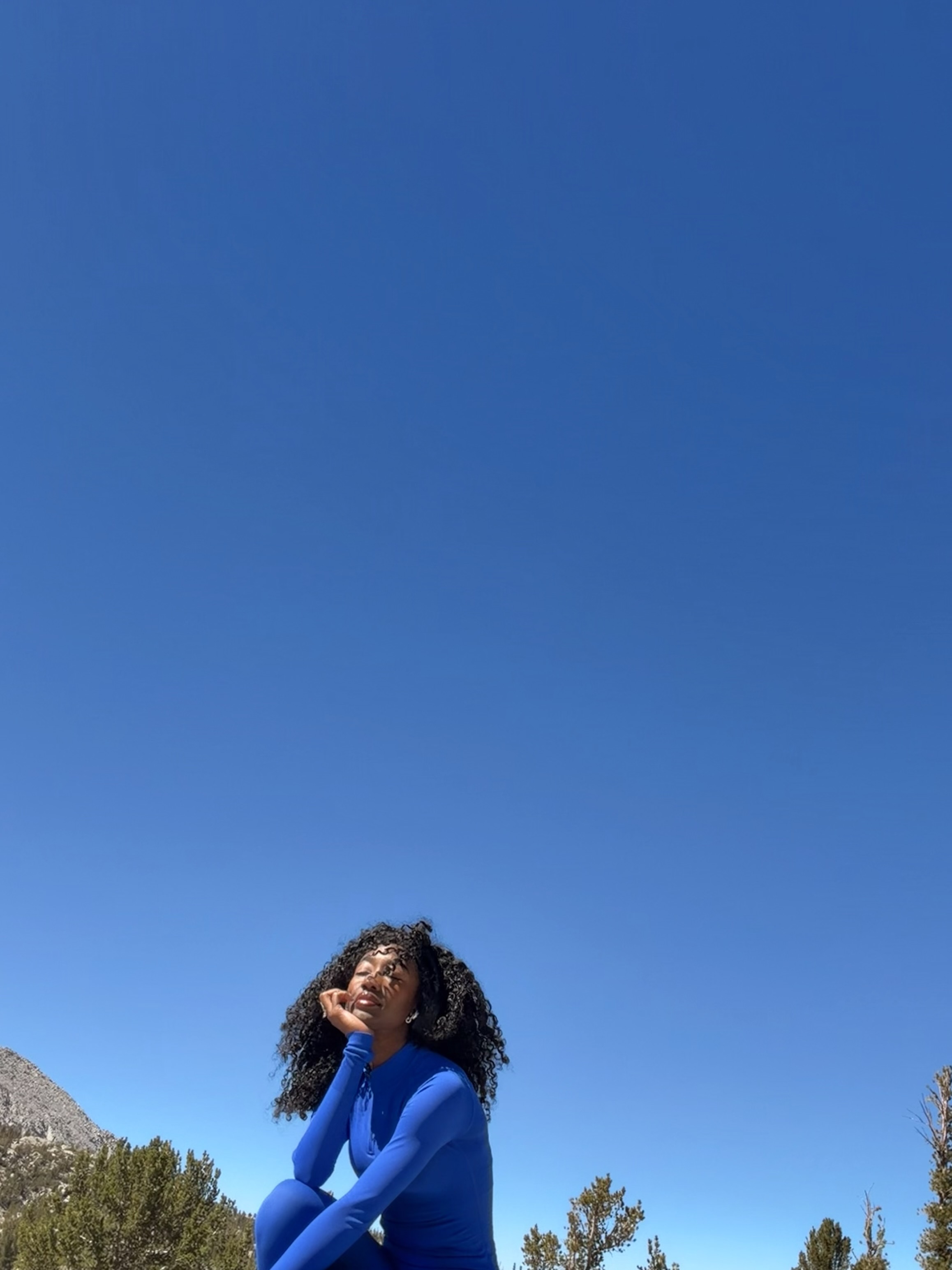 Cobalt self-portrait beneath a large blue sky