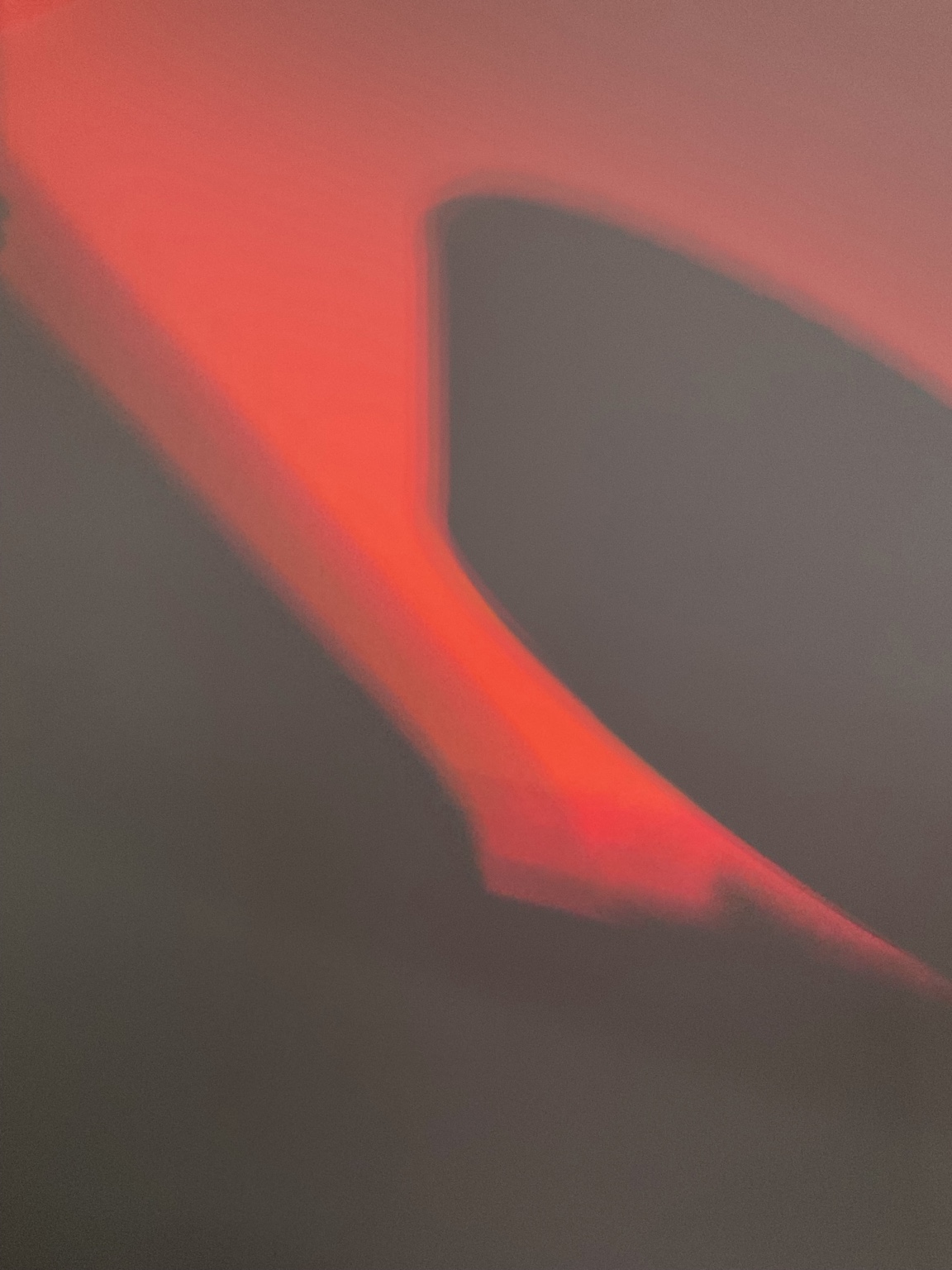 A red beam of light and geometric shadow forming an abstract composition