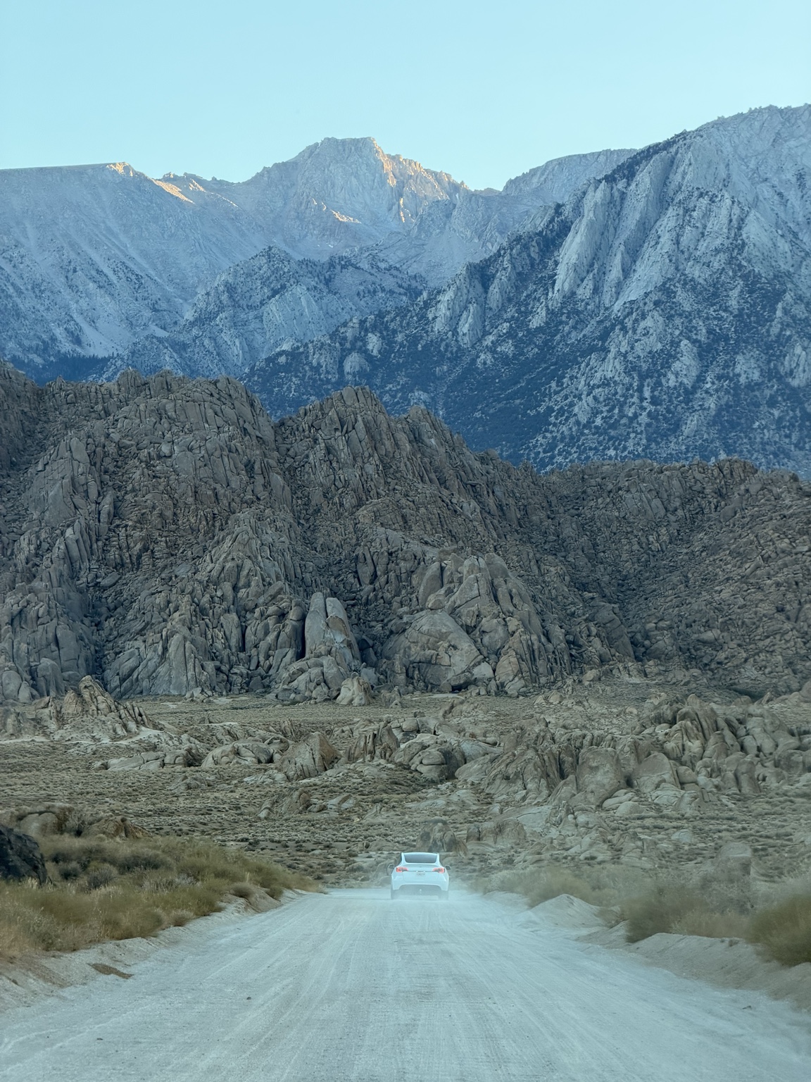 A small car moving through the monumental Eastern Sierra