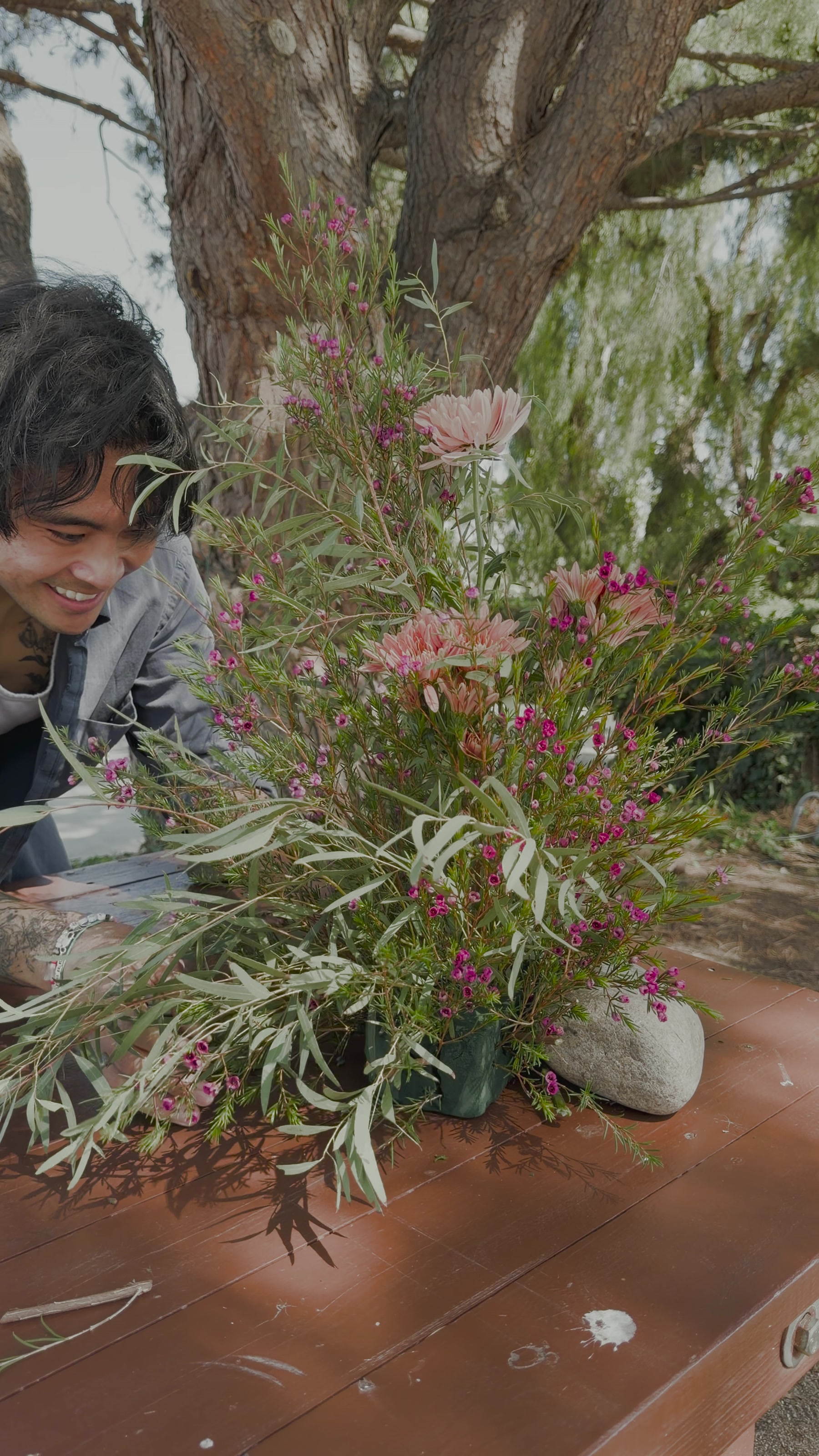 A collaborator shaping a loose floral arrangement onsite