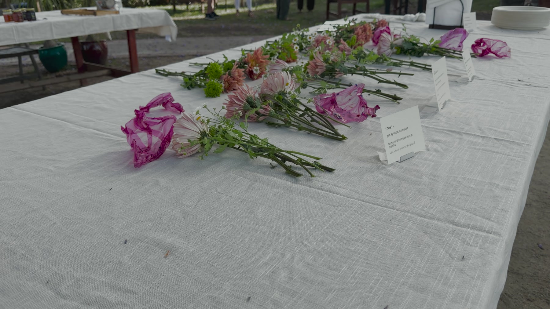 Cut flowers staged across a linen-covered table before placement