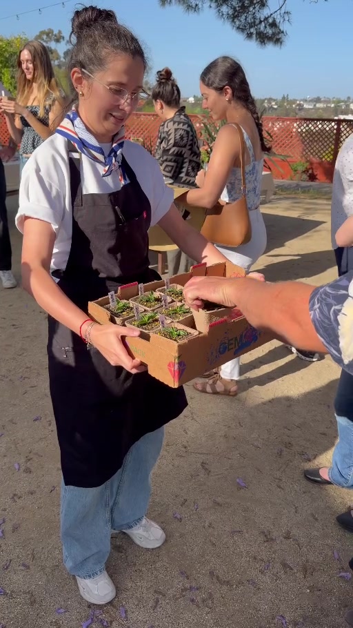 A maker offers guests miniature desserts styled as planted pots